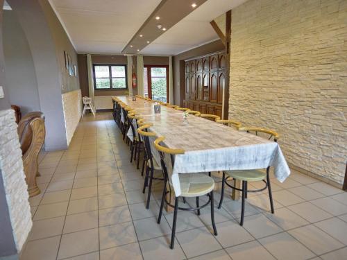 un comedor largo con una mesa larga y sillas en A large family house, en Stavelot