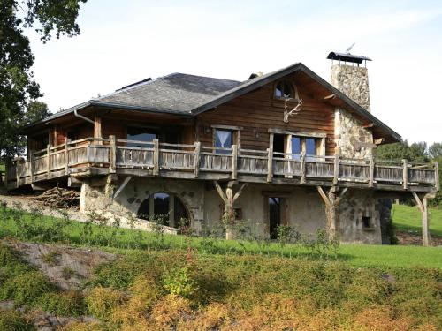 a large wooden house with a deck on top at Luxurious Chalet with Jacuzzi and Sauna in Thirimont in Waimes