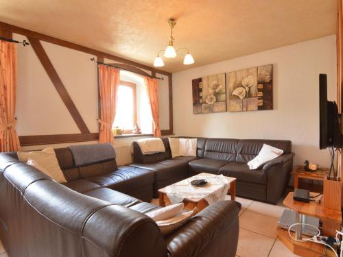 uma sala de estar com sofás de couro e uma mesa em Lovely Holiday Home in B tgenbach by the Lake em Bütgenbach