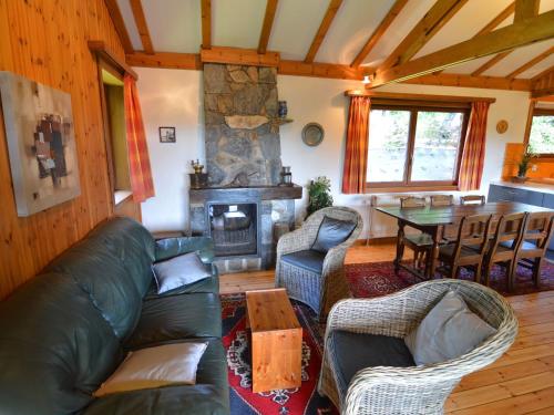 - un salon avec un canapé en cuir et une cheminée dans l'établissement Pretty cottage Ardennes near the Valley of Lesse, à Vencimont