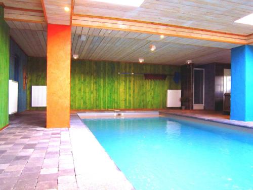 ウェームにあるLovely house with much luxury and comfortの緑の壁の客室内の大きなスイミングプール