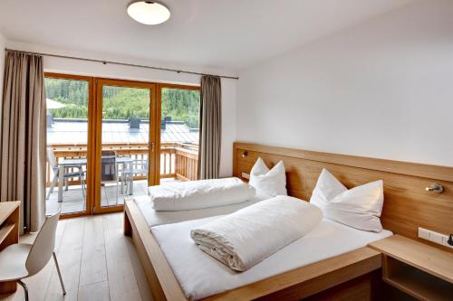 ゲルロスにあるGerlos Alpine Estateのベッドルーム1室(ベッド2台付)、バルコニーが備わります。