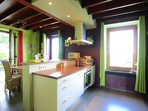 uma cozinha com armários brancos e paredes e janelas verdes em Modern Holiday Home in Neufch teau with Terrace em Neufchâteau