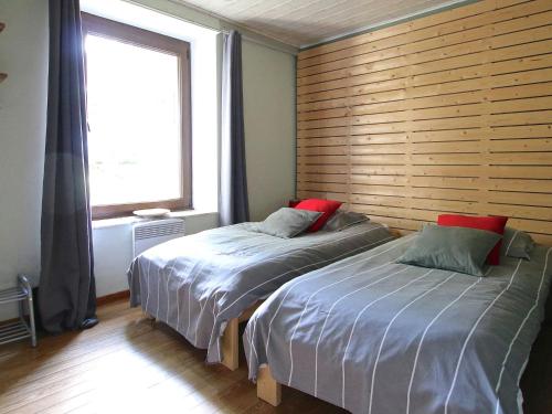 2 letti in una camera da letto con parete in legno di Modern Holiday Home in Neufch teau with Terrace a Neufchâteau