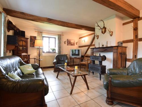 a living room with leather furniture and a fireplace at Authentic Cottage in Weris with Private Garden in Weris