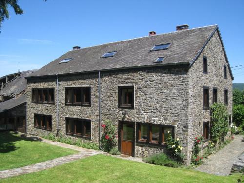 an old stone house with solar panels on it at Cosy holiday house near La Roche in Rendeux