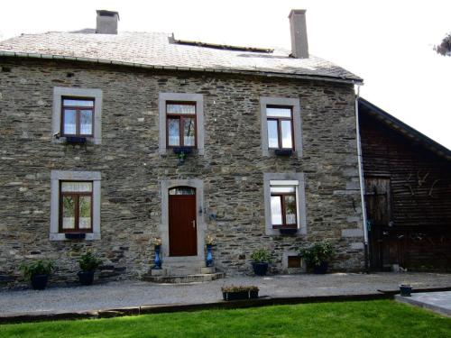 ein altes Steinhaus mit einer roten Tür in der Unterkunft holiday home in typical Ardennes style in Bérisménil