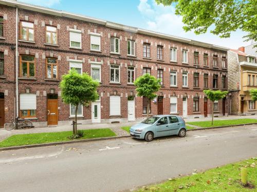 un pequeño coche aparcado frente a un edificio de ladrillo en Renovated city house en Kortrijk