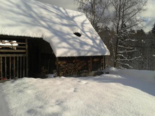 a pile of snow next to a log cabin at Vintage Holiday Home in Nejdek in Nejdek