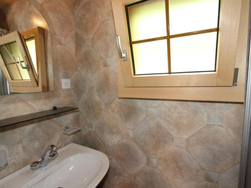 Un baño con lavabo y ventana. en Chalet in Valais near Ski Lift & Saas Valley, en Saas-Balen