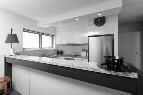 a kitchen with a large counter with a clock on it at La Mer Apartment 8, Noosa Heads in Noosa Heads