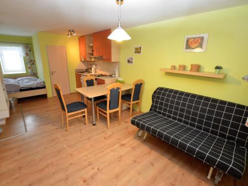 - un salon avec un canapé, une table et des chaises dans l'établissement Comfy Holiday Home near Forest in Medenec, à Měděnec