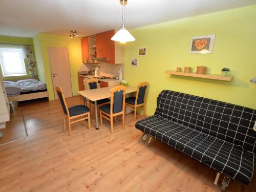 a living room with a couch and a table and chairs at Comfy Holiday Home near Forest in Medenec in Měděnec