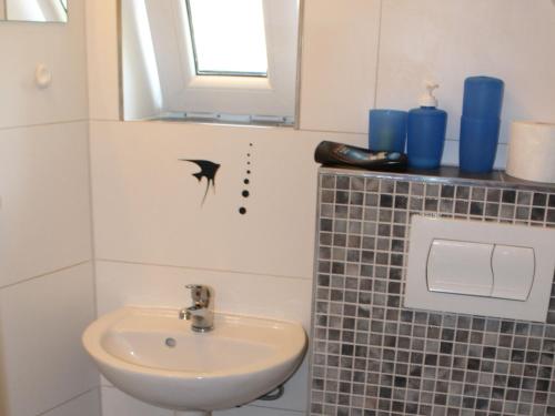a bathroom with a sink and a shark decal on the wall at Wohnung mit großem Garten an der Ostseeküste in Neubukow