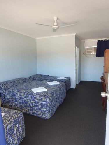 ein Hotelzimmer mit 2 Betten und einer Decke in der Unterkunft Kooyong Hotel in Mackay