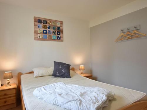 a bedroom with a bed with a white comforter at Cosy Holiday Home in Am Salzhaff by the Sea in Pepelow