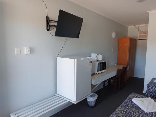 a room with a television and a bed in it at Kooyong Hotel in Mackay