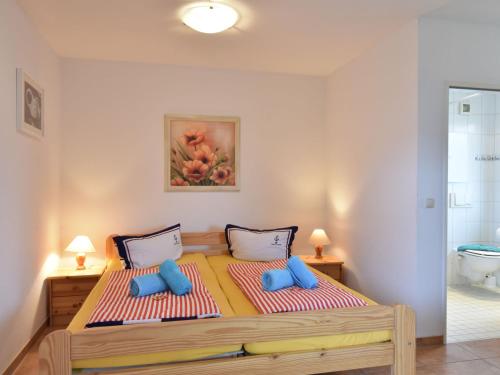 レリクにあるDelightful Bungalow in Rerik near Baltic Sea Coastのベッドルーム(青い枕の大型ベッド1台付)