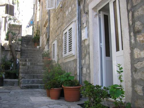 an alley with potted plants in front of a building at Rooms Megi in Dubrovnik