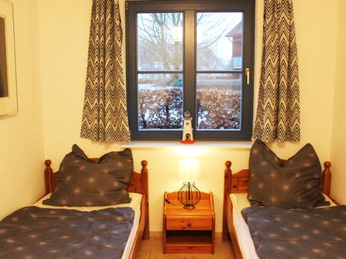 two beds in a room with a window at Charming Apartment in Boltenhagen with Terrace in Boltenhagen