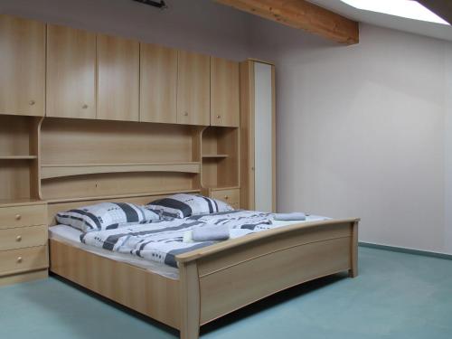 a bedroom with a large wooden bed with pillows at Spacious Apartment in Boddin near Baltic Sea in Boddin