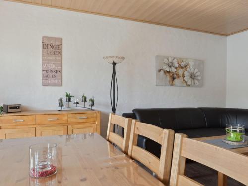 a living room with a black couch and a table at Holiday home in Winterberg with sauna in Winterberg