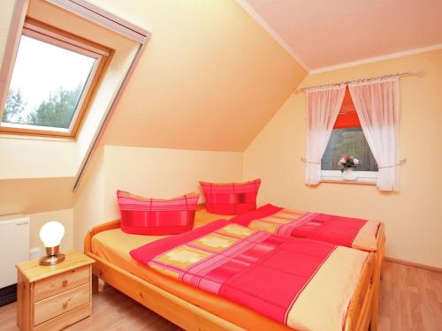 SchmogrowにあるHoliday home with terrace in Schmogrow Fehrowのベッドルーム1室(大型ベッド1台、赤い枕付)