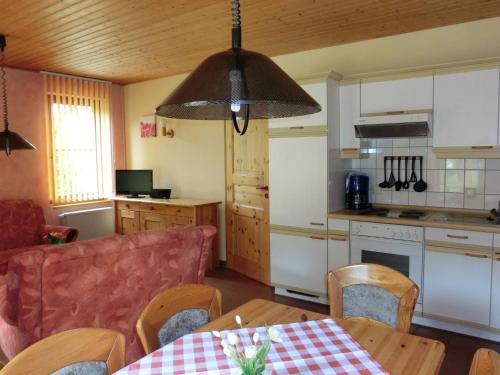 eine Küche und ein Wohnzimmer mit einem Tisch und einem Sofa in der Unterkunft Pleasant Holiday Home With Terrace in Schirgiswalde Germany in Schirgiswalde