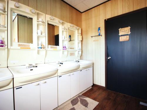 uma casa de banho com dois lavatórios e uma porta azul em Daigo House em Daigo