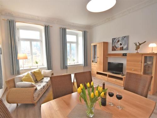 ein Wohnzimmer mit einem Sofa und einem Tisch mit Blumen in der Unterkunft Apartment in a villa with garden in Borstendorf in Wünschendorf