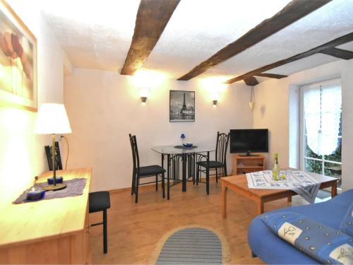 sala de estar con mesa, sillas y sofá en Small apartment in Hesse with terrace and garden, en Frielendorf