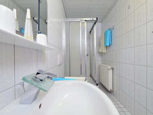 ein weißes Badezimmer mit Waschbecken und Dusche in der Unterkunft Apartment in Eimelrod with Panoramic Views in Willingen