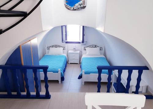 Duas camas num quarto no sótão com azul e branco em White & Blue em Perissa