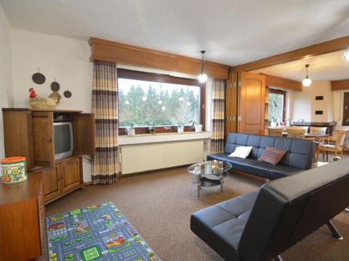 a living room with a couch and a television at Holiday home in Monschau with sauna in Alzen