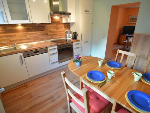 uma cozinha com uma mesa de madeira com placas azuis em Spacious Apartment in Meisburg with Terrace em Meisburg