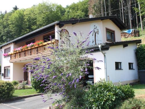 una casa con balcone e fiori viola di Mountain view Apartment in Mullenborn Garden a Gerolstein