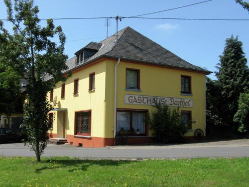 żółty budynek z znakiem na boku w obiekcie Large group house beautifully located in Eifel w mieście Ammeldingen