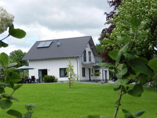 a white house with solar panels on the roof at Serene Villa in Medebach K stelberg near Lake in Medebach