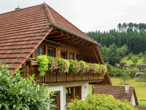 a house with a balcony with flowers on it at Charming Apartment in Regelsbach near City Centre in Schuttertal