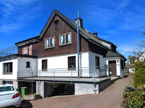 ein Haus mit einem Balkon und einem Auto vor dem Haus in der Unterkunft Detached house with sauna 50m from ski lifts in Winterberg