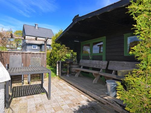 eine Holzterrasse mit einer Bank und einem Haus in der Unterkunft Detached house with sauna 50m from ski lifts in Winterberg