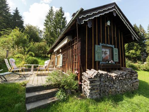 a small log cabin with a porch and a patio at Idyllic holiday home with terrace in Hohenpeißenberg