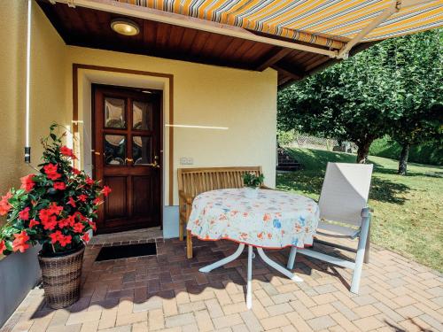 a table and chairs on a patio in front of a house at Apartment near the forest in Plankenstein in Plankenfels