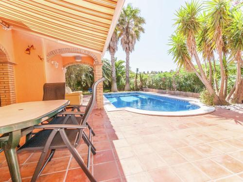 un patio con mesa y sillas y una piscina en Belvilla by OYO Nautic Park, en Sant Pere Pescador