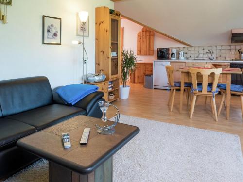 a living room with a couch and a table and a kitchen at Apartment in G tenbach with nearby forest in Furtwangen