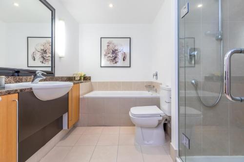 een badkamer met een toilet, een wastafel en een douche bij Quiet Newly Renovated Getaway in Auckland