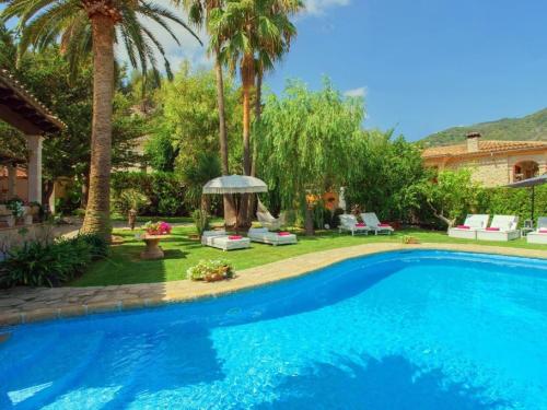 una piscina en un patio con palmeras en Belvilla by OYO Font, en Biniamar
