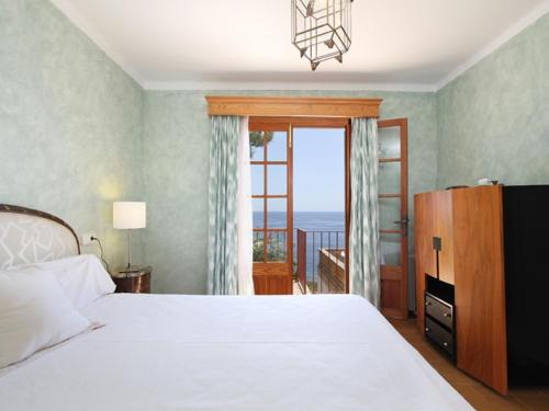 a bedroom with a bed and a view of the ocean at Belvilla by OYO Ratjada in Font de Sa Cala