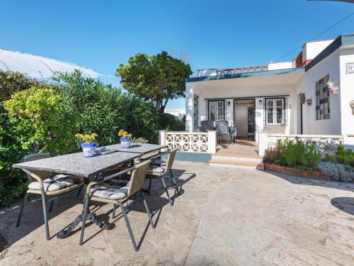 un patio con mesa y sillas frente a una casa en Belvilla by OYO Casa Myjoli, en Vinarós