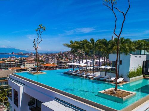 a swimming pool on the roof of a building with palm trees at PIER 57 - 710 Fabulous & Luxurious 2 BR Penthouse in Puerto Vallarta